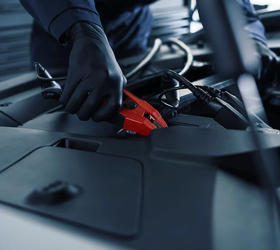 Cadillac service technician hooking up to battery