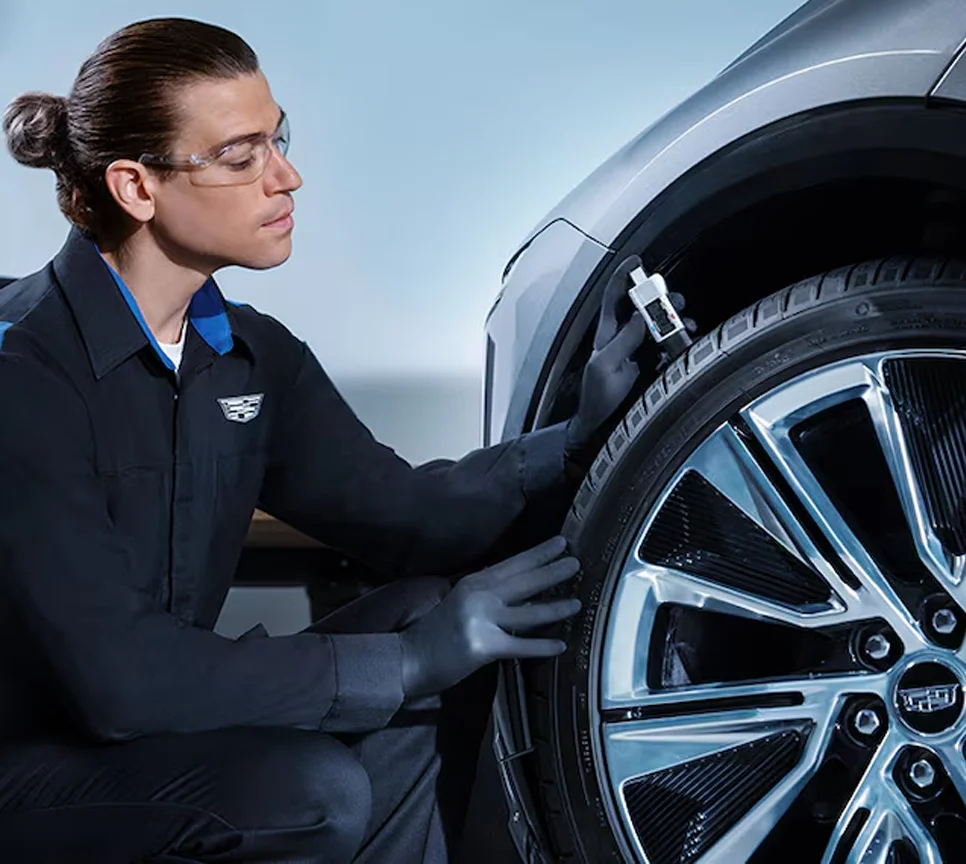 Cadillac service tech looking at tire
