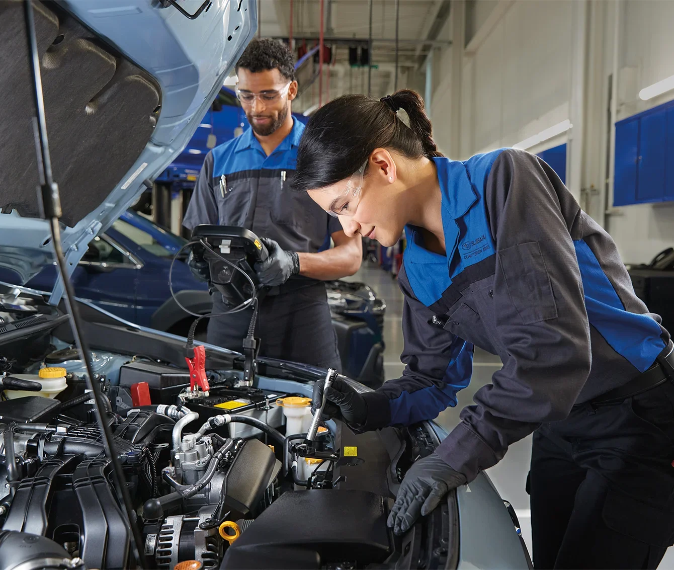 Two Subaru Service Techs Looking Under a Hood