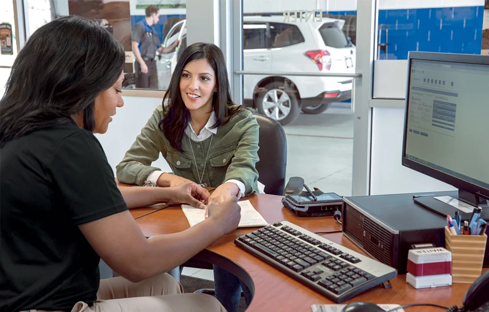 Woman sitting at a desk speaking with a service representative