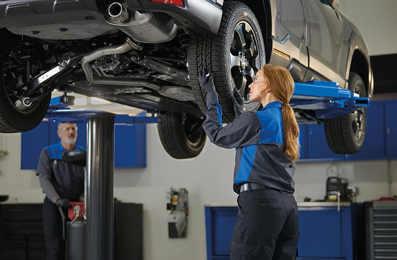 Subaru Service Tech looking under car